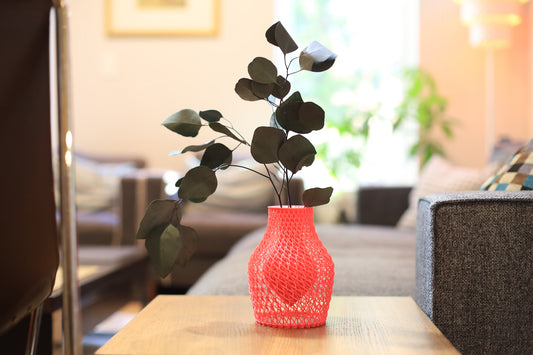 Hot pink vase with eucalyptus leaves on a wooden table in a living room setting